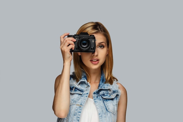 Foto grátis retrato de fotógrafo feminino loiro isolado em fundo cinza.