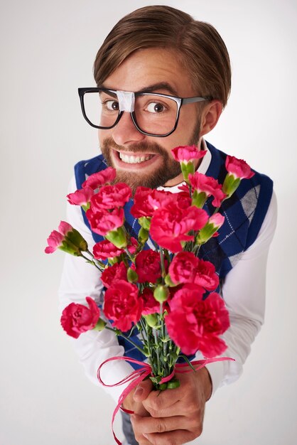 Retrato de geek segurando um buquê de flores isolado