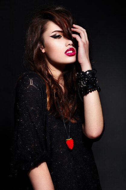 retrato de glamour do modelo sexy elegante caucasiano morena jovem bonita em pano preto com maquiagem brilhante com acessórios com pele limpa perfeita com cabelo saudável encaracolado com lábios vermelhos