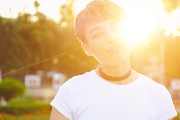 Foto grátis retrato de hipster feminino com maquiagem natural e cabelo curto, aproveitando o tempo de lazer ao ar livre