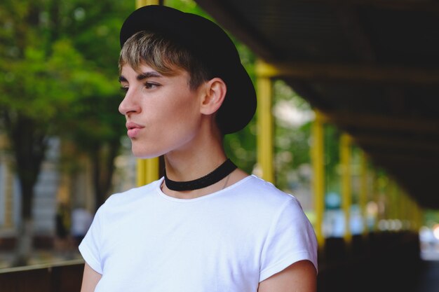 Retrato de hipster feminino com maquiagem natural e cabelo curto, aproveitando o tempo de lazer ao ar livre