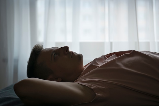 Retrato de homem adulto com cortinas e sombra da janela