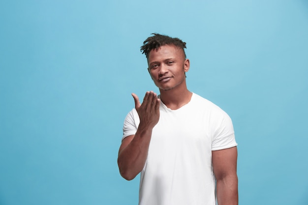 Foto grátis retrato de homem afro-americano atraente com beijo do ar isolado sobre fundo azul