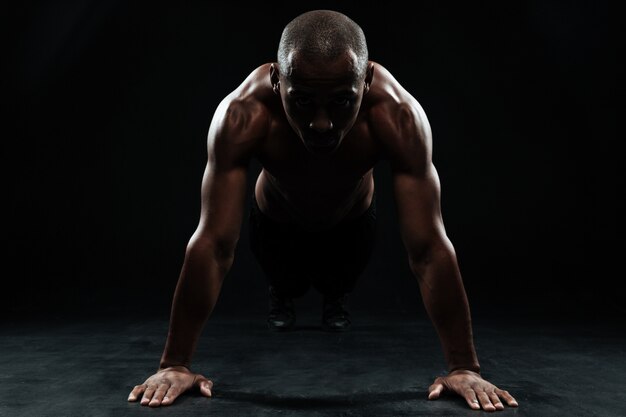 Retrato de homem afro-americano de esportes, fazendo exercícios de flexão