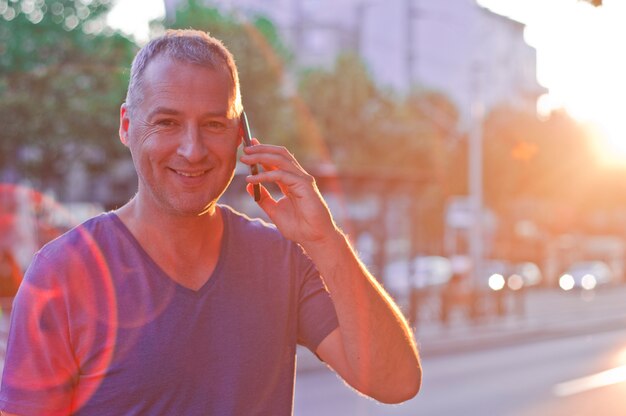 Retrato de homem alegre falando ao telefone.