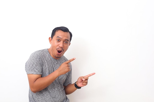 Retrato de homem asiático apontando algo no espaço vazio. isolado em branco com copyspace
