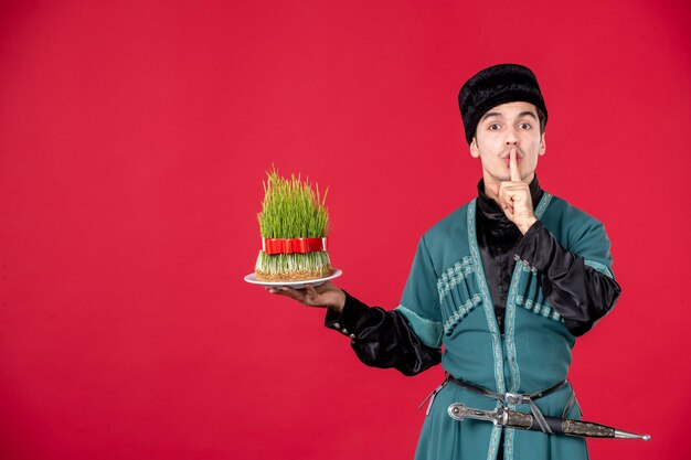 Retrato de homem azeri em traje tradicional segurando semeni estúdio tiro vermelho dançarina novruz primavera