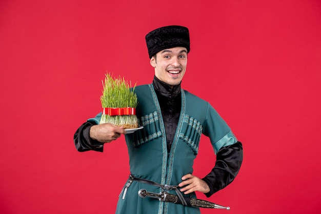 Retrato de homem azeri em traje tradicional segurando semeni estúdio tiro vermelho dançarino novruz artista primavera