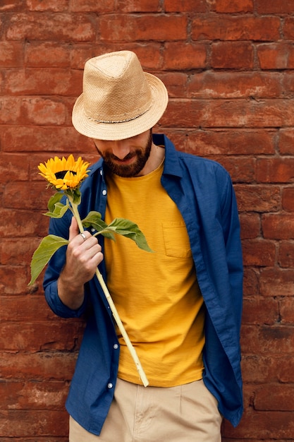 Retrato de homem barbudo bonito com girassóis