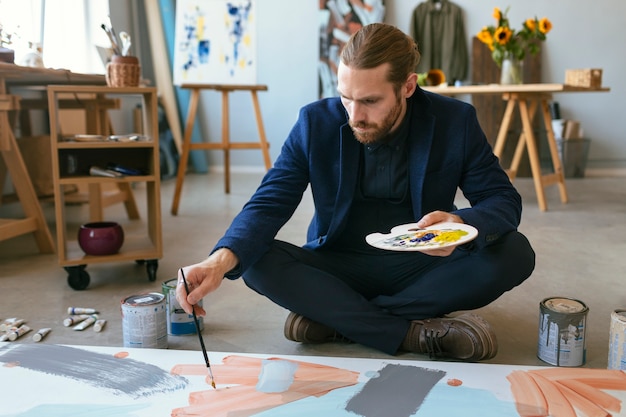 Foto grátis retrato de homem barbudo bonito em um estúdio de arte