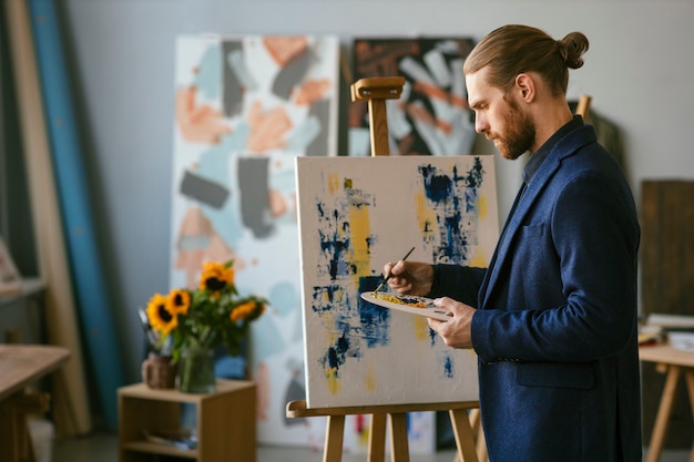 Foto grátis retrato de homem barbudo em um estúdio de arte