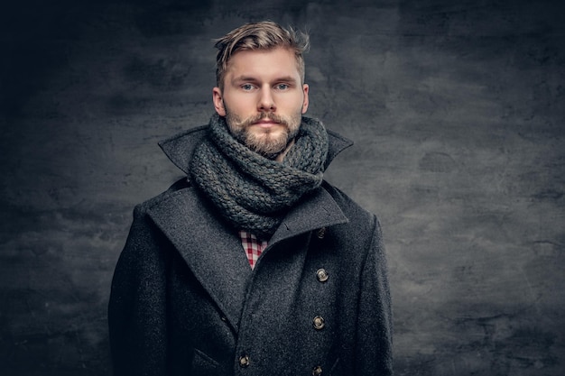 Retrato de homem barbudo vestido com uma jaqueta cinza.