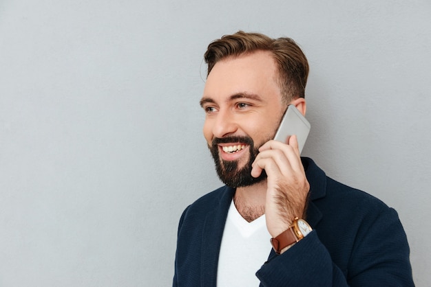 Retrato de homem bonito, falando no smartphone isolado