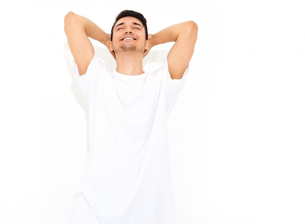 Foto grátis retrato de homem bonito modelo jovem sorridente, vestido com roupas jeans e posando de t-shirt. tocando sua cabeça