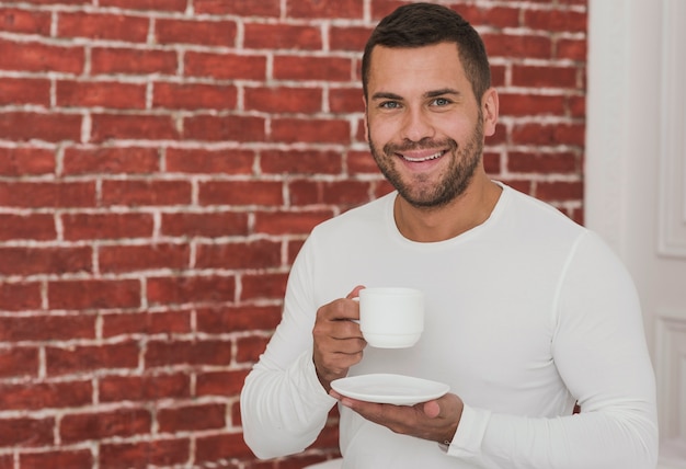 Retrato de homem bonito, segurando uma xícara