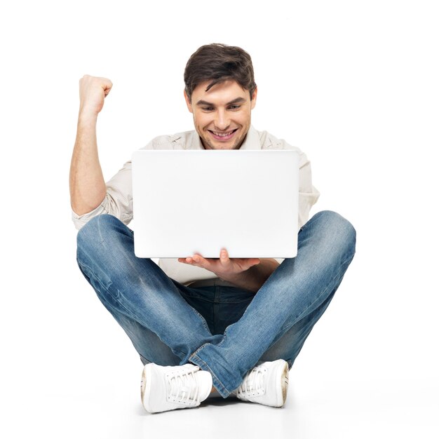 Retrato de homem de sucesso feliz trabalhando no laptop em casuais isolado no branco.