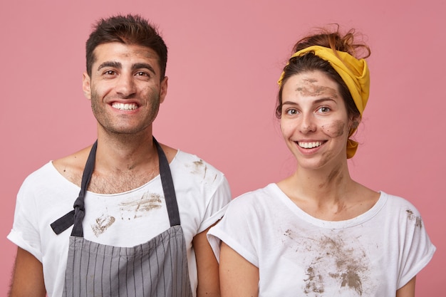 Retrato de homem e mulher sorridentes em camisetas brancas sujas