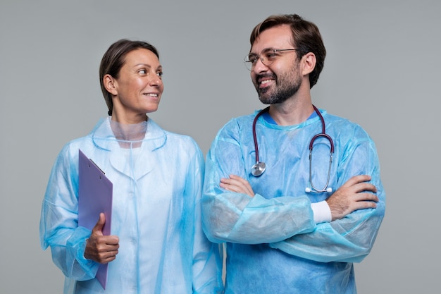 Retrato de homem e mulher vestindo aventais médicos e segurando a área de transferência