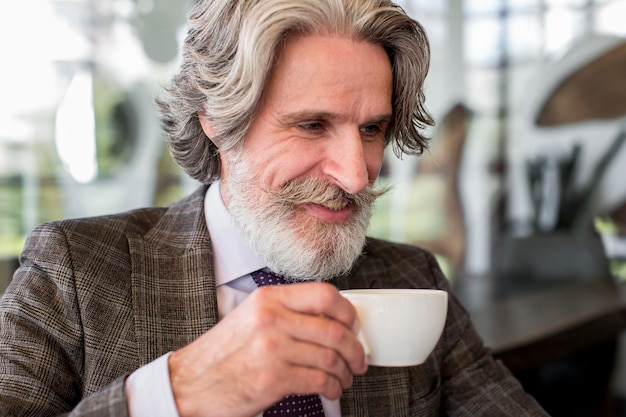 Foto grátis retrato de homem elegante tomando café