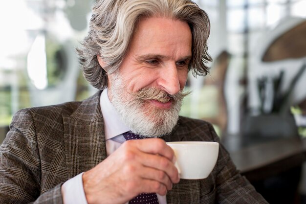 Retrato de homem elegante tomando café