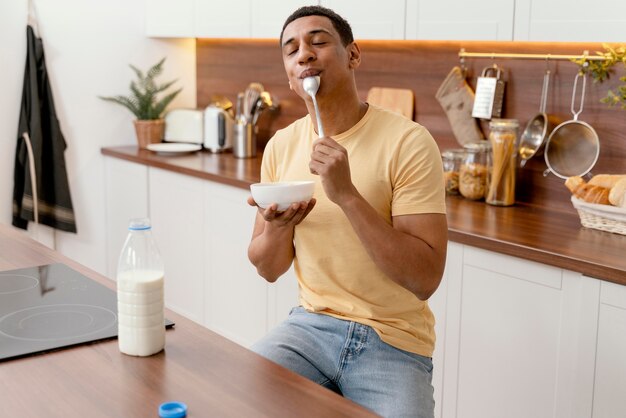 Retrato de homem em casa comendo