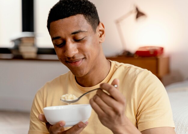 Retrato de homem em casa comendo