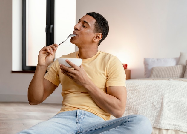 Retrato de homem em casa comendo