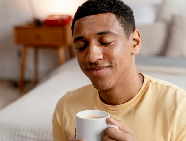 Retrato de homem em casa tomando café