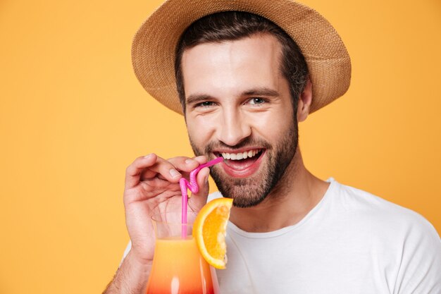 Retrato de homem engraçado segurando cocktail perto da boca