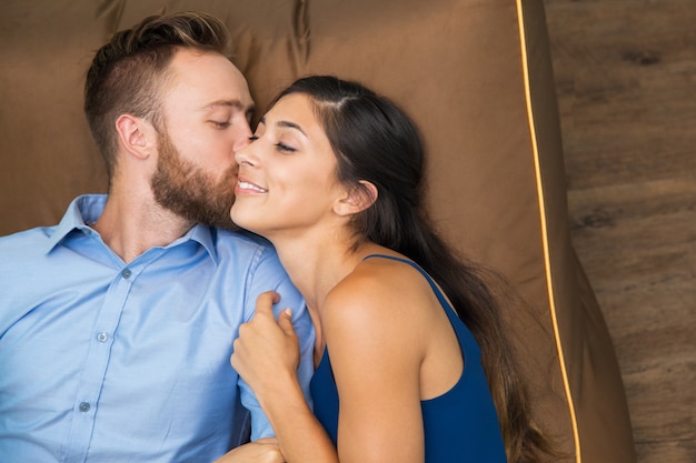 Retrato de homem feliz beijando sua esposa na bochecha