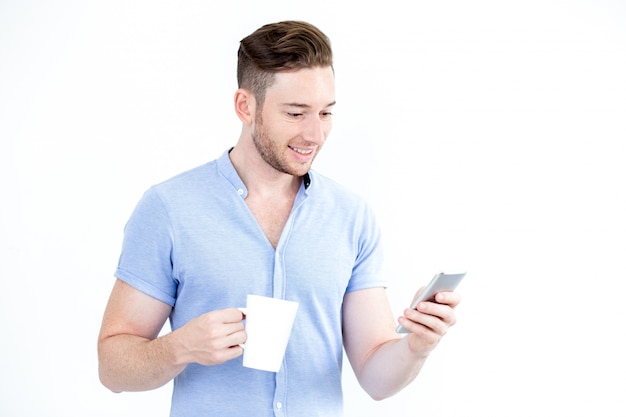 Retrato de homem feliz com copo usando smartphone