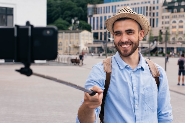 Retrato, de, homem feliz, desgastar, chapéu, levando, selfie, ao ar livre