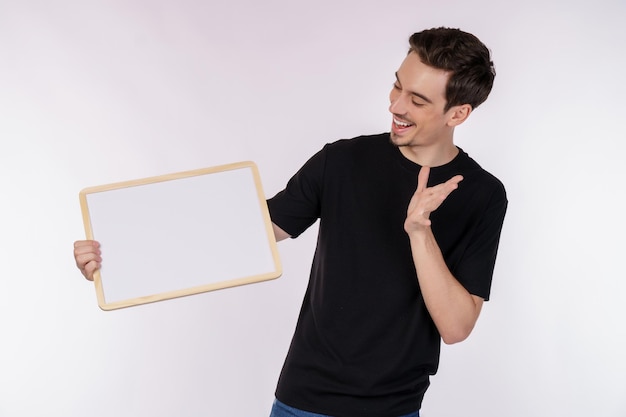 Foto grátis retrato de homem feliz mostrando a tabuleta em branco no fundo branco isolado