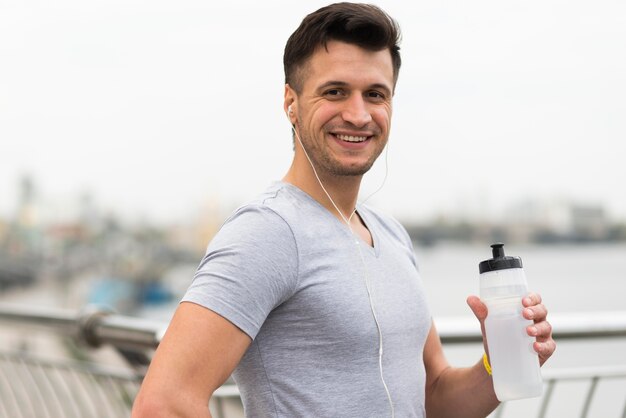 Retrato de homem feliz, segurando a garrafa de água