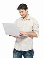 Foto grátis retrato de homem feliz sorridente com laptop em casuals - isolado no branco. comunicação de conceito.