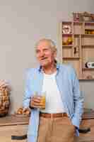Foto grátis retrato de homem idoso, segurando o copo de suco
