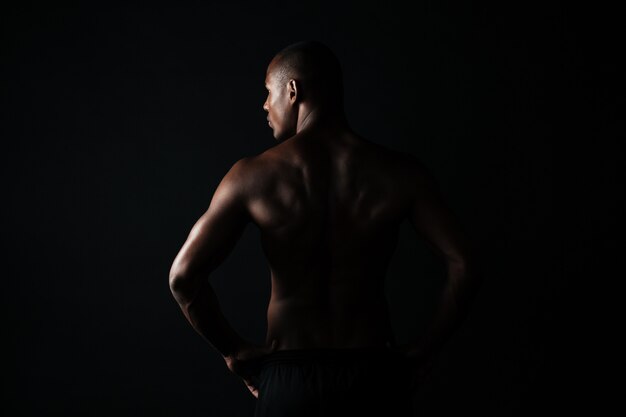 Retrato de homem jovem afroamerican esportes, em pé, olhando de lado