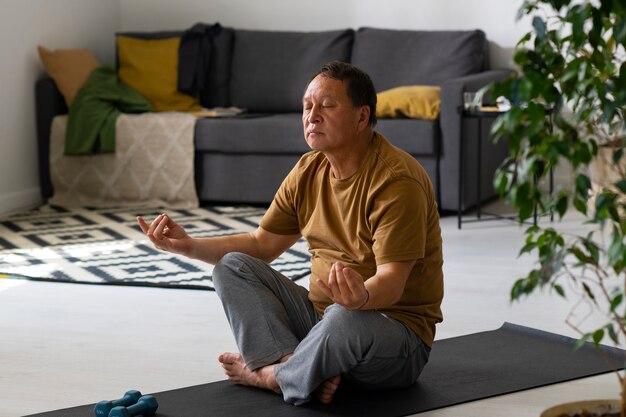 Retrato de homem mais velho meditando em casa