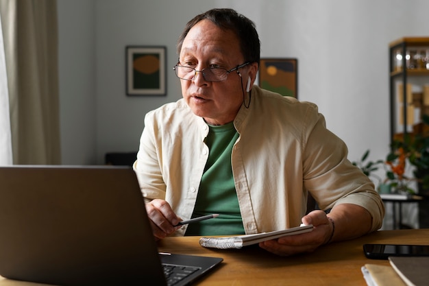 Retrato de homem mais velho usando laptop em casa