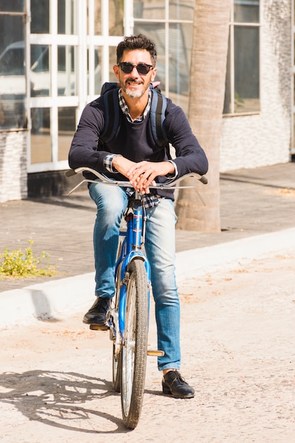 Retrato, de, homem moderno, óculos sol preto, sentar bicicleta