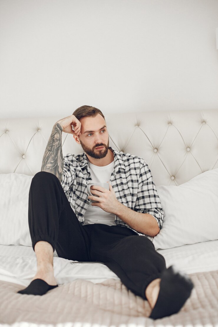 Foto grátis retrato de homem relaxando em casa com smartphone
