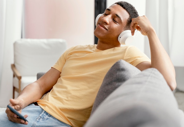 Retrato de homem relaxando em casa enquanto ouve música