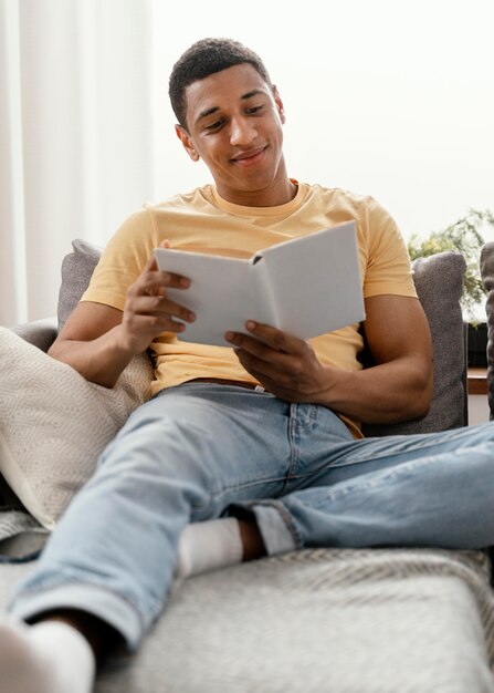 Retrato de homem relaxando em casa lendo