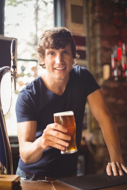 Retrato de homem segurando copo de cerveja