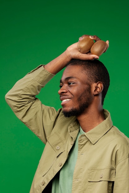 Foto grátis retrato de homem segurando kiwi