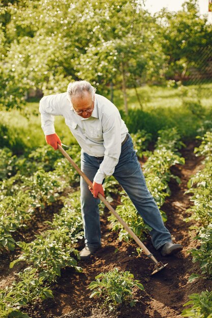 Retrato de homem sênior com um chapéu de jardinagem com a neta