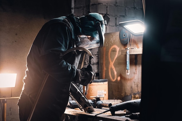 Retrato de homem trabalhando ocupado em seu local de trabalho na fábrica de metal.