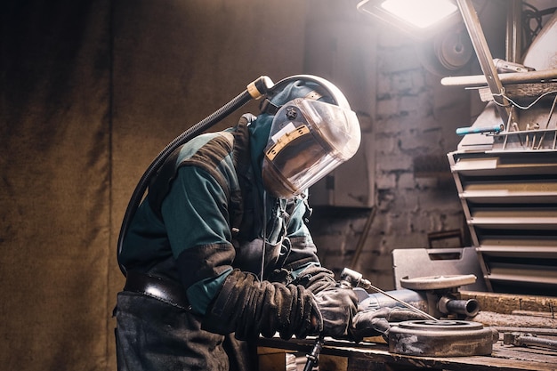 Retrato de homem trabalhando ocupado em seu local de trabalho na fábrica de metal.