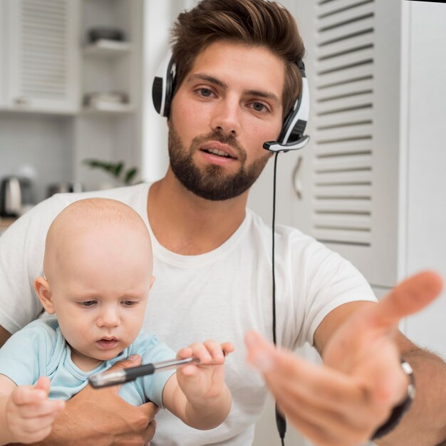 Retrato de homem trabalhando segurando um bebê