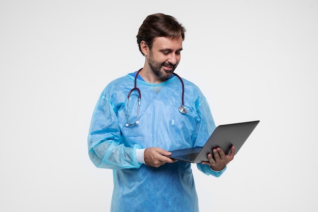 Retrato de homem vestindo bata médica e segurando laptop